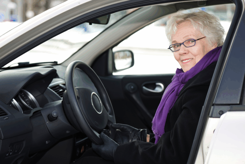 Woman living with dementia driving in winter, smiling